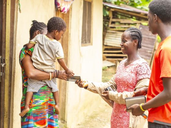 Sharing the Gospel at the door with a mother and her child at Dompim