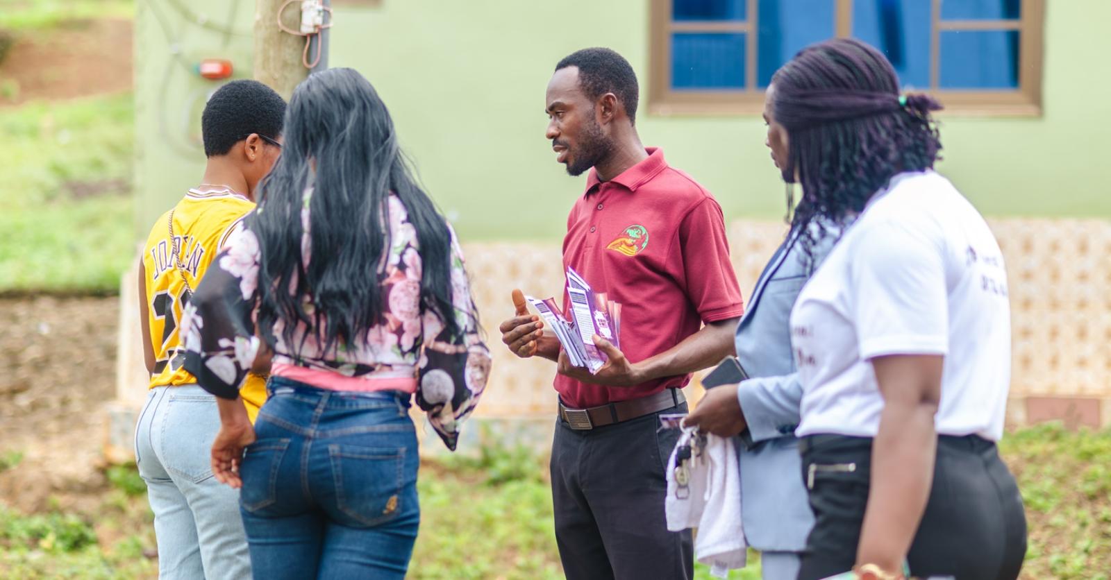 A crew member preaching to a gathered crowd during a community outreach